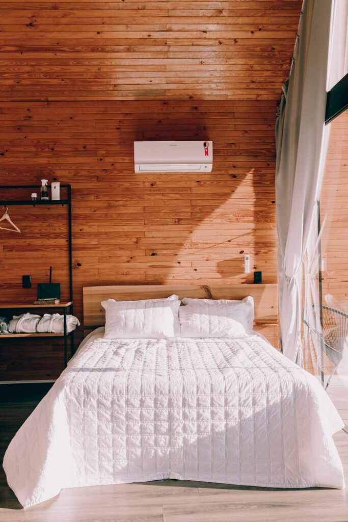 pexels photo 27638171 Charming cabin bedroom featuring wooden walls and sunlight streaming in.